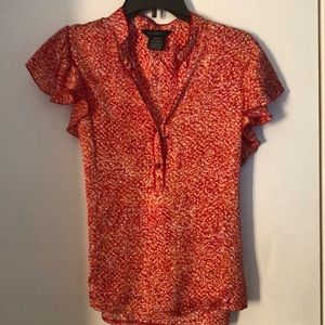 George orange, red and white top. Two buttons is front and tie in back